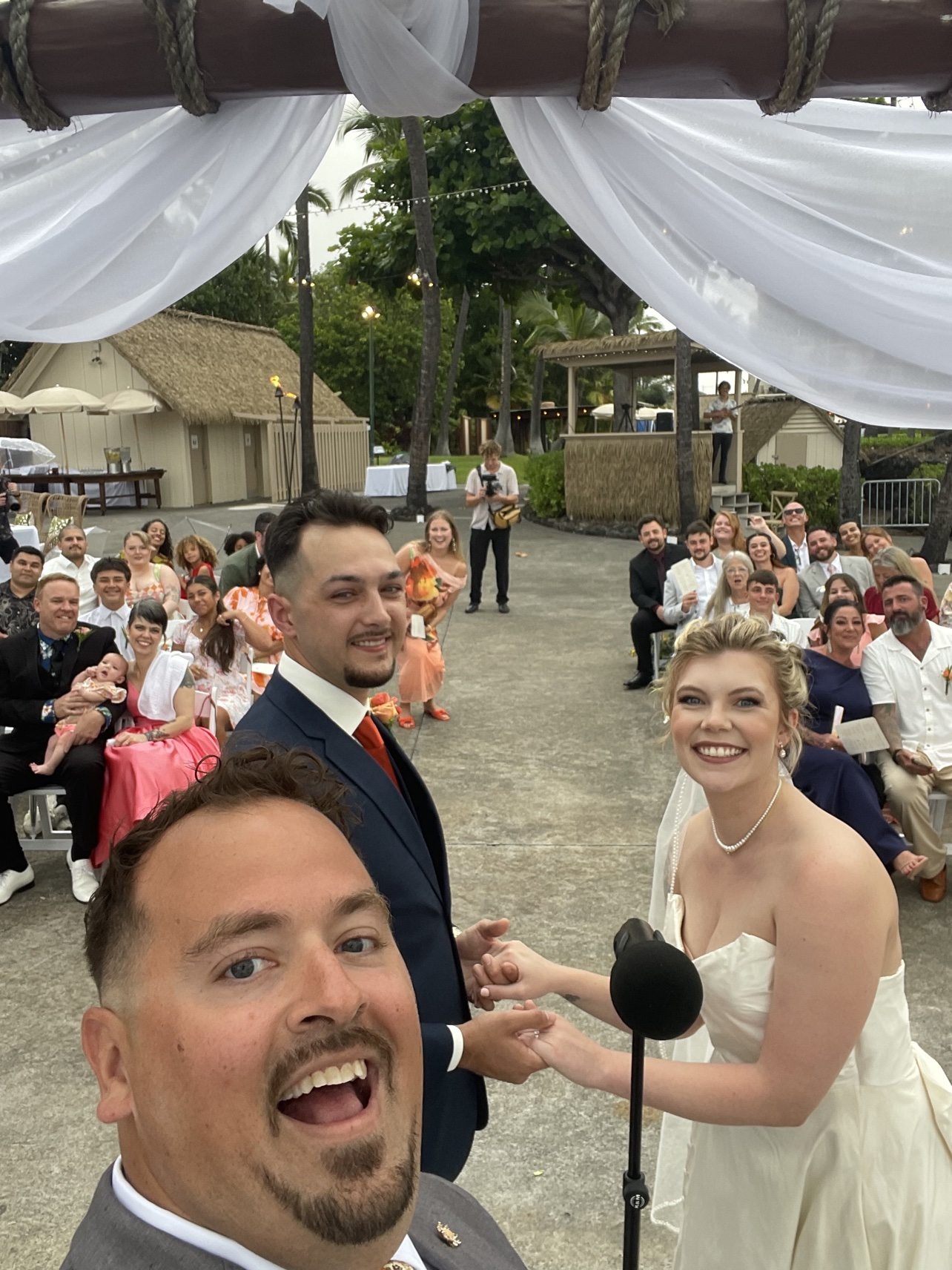 Peter taking a joyful selfie with a couple and their wedding guests